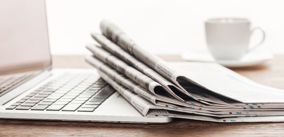 laptop-cup-of-coffee-and-stack-of-newspapers-on-w-2021-08-30-19-47-44-utc(1)